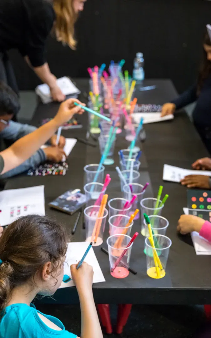 Enfants coloriant des mots avec des stylos